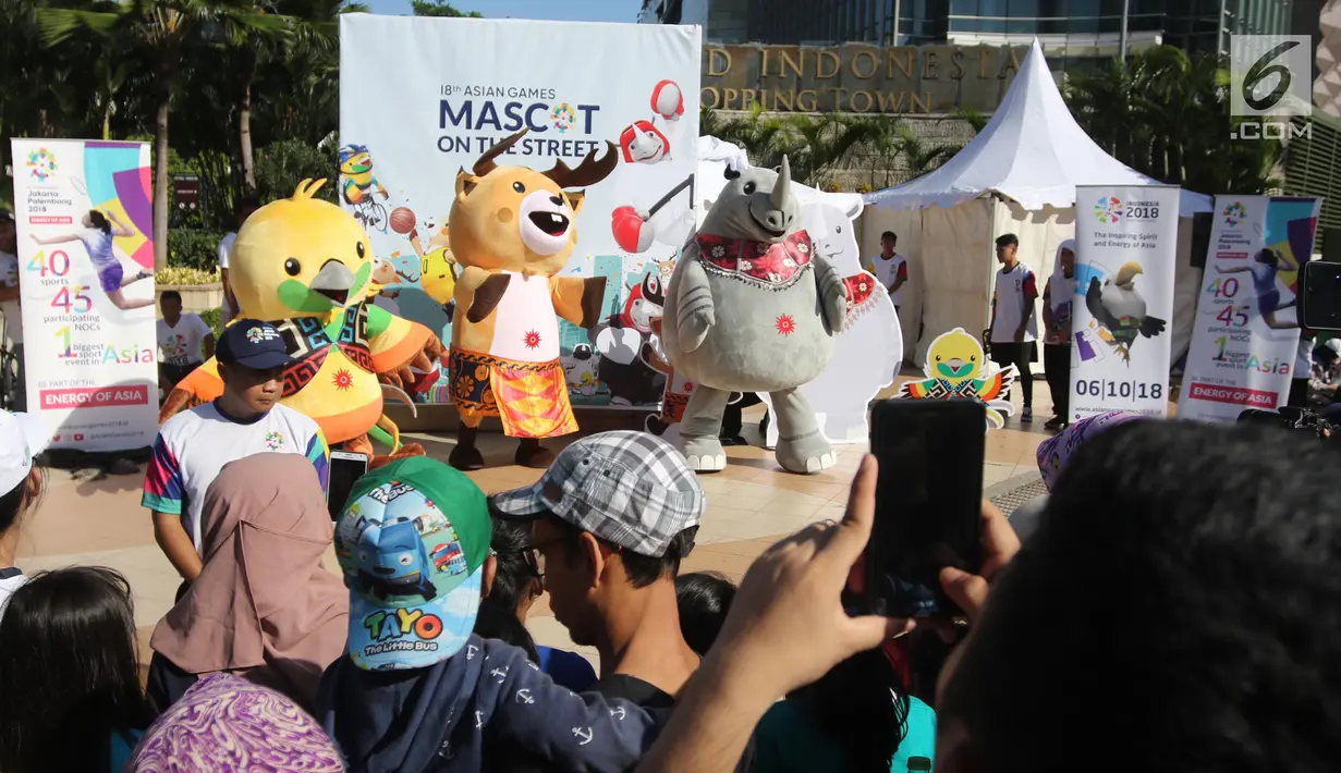 Maskot Asian Games 2018 Bhin-Bhin (kiri), Atung (tengah) dan Kaka (kanan) menghibur warga saat hari bebas kendaraan bermotor di kawasan Bundaran HI, Jakarta, Minggu (1/4). (Liputan6.com/Arya Manggala)