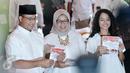 Cagub DKI Jakarta, Anies Baswedan bersama istri dan anaknya menunjukan kertas suara saat akan menggunakan hak pilihnya di TPS 28 Cilandak, Jakarta Selatan, Rabu (19/4). (Liputan6.com/Yoppy Renato)