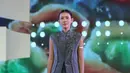 Shenina Cinnamon kenakan atasan vest warna abu-abu kerah tinggi dengan aksen beads warna senada. Dipadukan bawahan kain songket hitam bordir emas serta high heels hitamnya. [Adrian/Fimela]