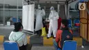 Petugas saat melakukan swab test antigen kepada para pemudik saat arus balik Lebaran di Terminal Pulogebang, Jakarta, Jumat (21/5/2021). Satu minggu setelah Lebaran, pemudik yang tiba di Terminal Pulogebang wajib menjalani tes COVID-19. (merdeka.com/Imam Buhori)