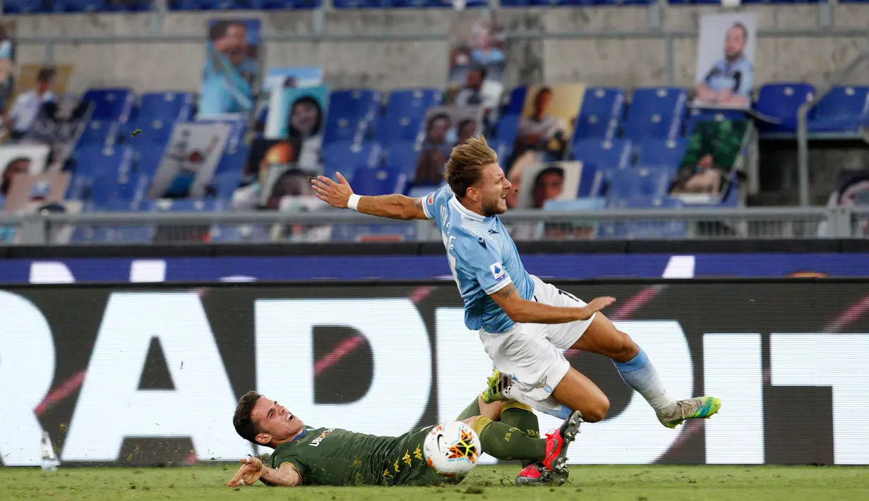 Pemain Brescia, Andrea Papetti berebut bola dengan striker Lazio, Ciro Immobile pada laga pekan ke-37 Liga Italia di Stadion Olimpico, Rabu (29/7/2020). Lazio menaklukkan tamunya Brescia dengan skor 2-0. (AP Photo/Riccardo De Luca)