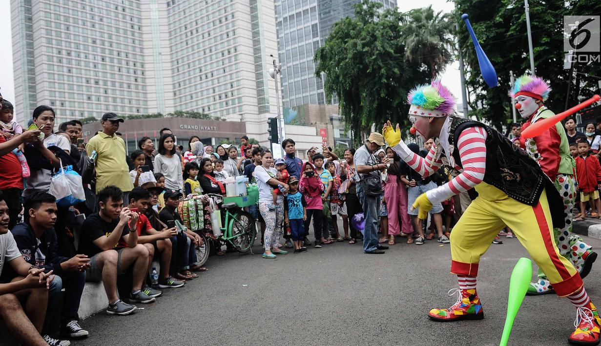 Aksi badut yang tergabung dalam Aku Badut Indonesia menghibur masyarakat saat car free day di Bunderan HI, Jakarta, Minggu (9/12). Aksi tersebut bentuk kampanye positif bertujuan mengajak masyarakat peduli terhadap sesama. (Liputan6.com/Faizal Fanani)