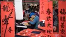 Chunlian merupakan dekorasi Imlek berupa dua kertas merah panjang yang bertuliskan kaligrafi huruf Mandarin. (Sam Yeh/AFP)