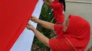 Sejumlah warga tampak serius menjahit bendera merah putih saat mengikuti lomba di Kelurahan Pekojan, Jakarta, Minggu (16/8/2015). Sebanyak 700 ibu-ibu mengikuti lomba menjahit bendera Merah Putih sepanjang 500 meter. (Liputan6.com/Panji Diksana)