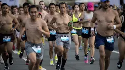 Peserta berlari dengan bertelanjang dada saat berpartisipasi pada The "Underpants Run" di Manila, Filipina, 8 April 2018. Ratusan orang hanya mengenakan pakaian yang minim berlari di sekitar distrik perbelanjaan kelas atas Manila. (NOEL CELIS / AFP)