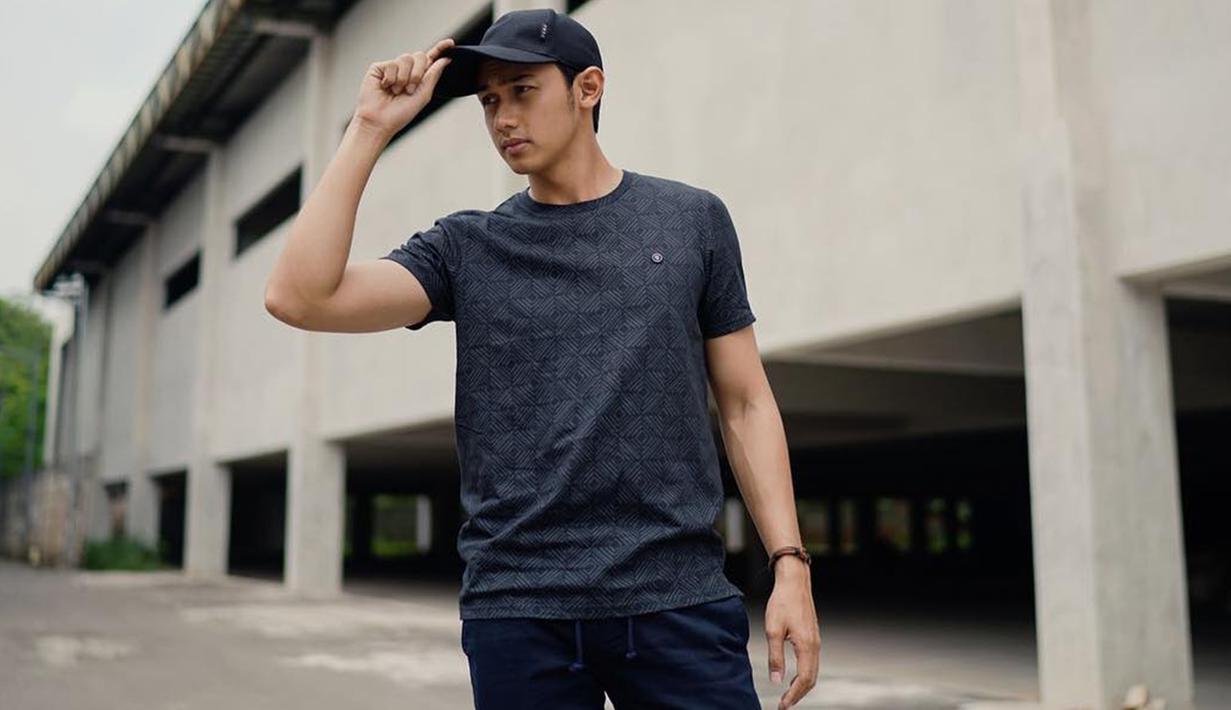 Ia cukup sering mengenakan busana berwarna gelap. Penampilan pesinetron Cinta Karena Cinta ini juga terlihat santai dnegan mengenakan kaus dan topi berwarna abu-abu yang dipadukan dengan aksesoris gelang di salah satu tangannya. (Liputan6.com/IG/@hitocaesar)