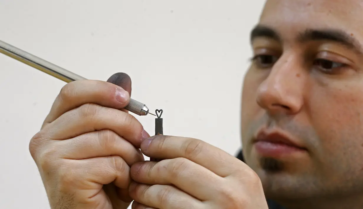 Jasenko Djordjevic saat mengukir ujung pensil menjadi bentuk hati di Tuzla, Bosnia dan Herzegovina, Selasa (26/4). Keterampilan Djordjevic membutuhkan konsentrasi penuh saat membuat ukiran miniatur. (REUTERS / Dado Ruvic)