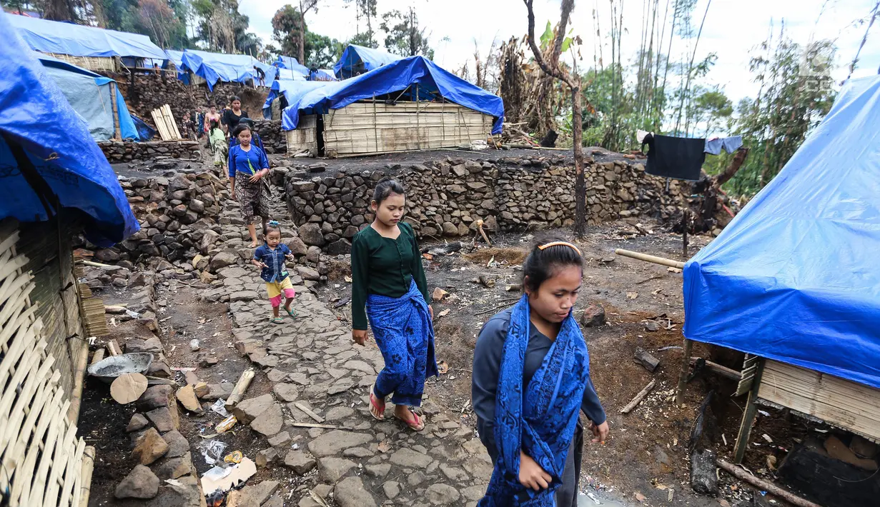 Sejumlah perempuan Suku Baduy Luar berjalan di lokasi bekas kebakaran Kampung Cisaban II, Desa Kanekes, Banten, Kamis (01/6). Warga Baduy Luar mulai membangun kembali rumah mereka yang terbakar beberapa waktu lalu. (Liputan6.com/Fery Pradolo)