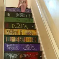 Seorang perempuan memilih untuk menghias anak tangga di rumah dengan cover buku favoritnya. (Via: boredpanda.com)
