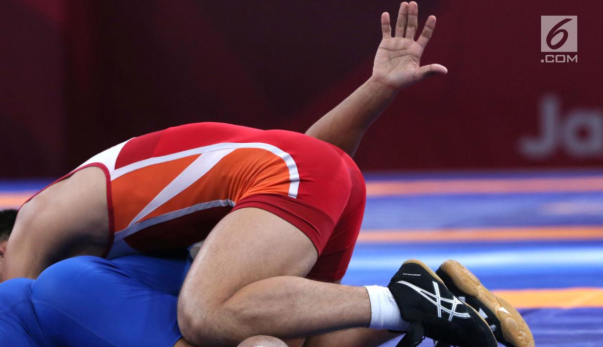 Pegulat putra Indonesia, Muhammad Aliansyah saat bertarung melawan pegulat Korea Utara Kim Myong Chol pada kelas putra 67 Kg di arena gulat JCC Senayan, Selasa (21/8). (Liputan6.com/Fery Pradolo)