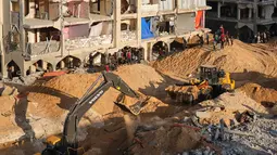 Tim pencari dan penyelamat dari Mesir bersama Komite Internasional Palang Merah (ICRC) mengerahkan alat berat untuk mempercepat pencarian sisa-sisa jenazah sandera Israel di reruntuhan Kota Hamad, Khan Younis, bagian selatan Jalur Gaza, pada Minggu 26 Oktober 2025. (AP Photo/Jehad Alshrafi)