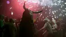 Seorang warga berpakaian seperti hantu dengan memegang tongkat kembang api selama perayaan " Correfocs ", Mallorca, Spanyol, (24/1). Orang - orang menari sambil men yalakan kembang api diantara kerumunan. (REUTERS / Enrique Calvo)