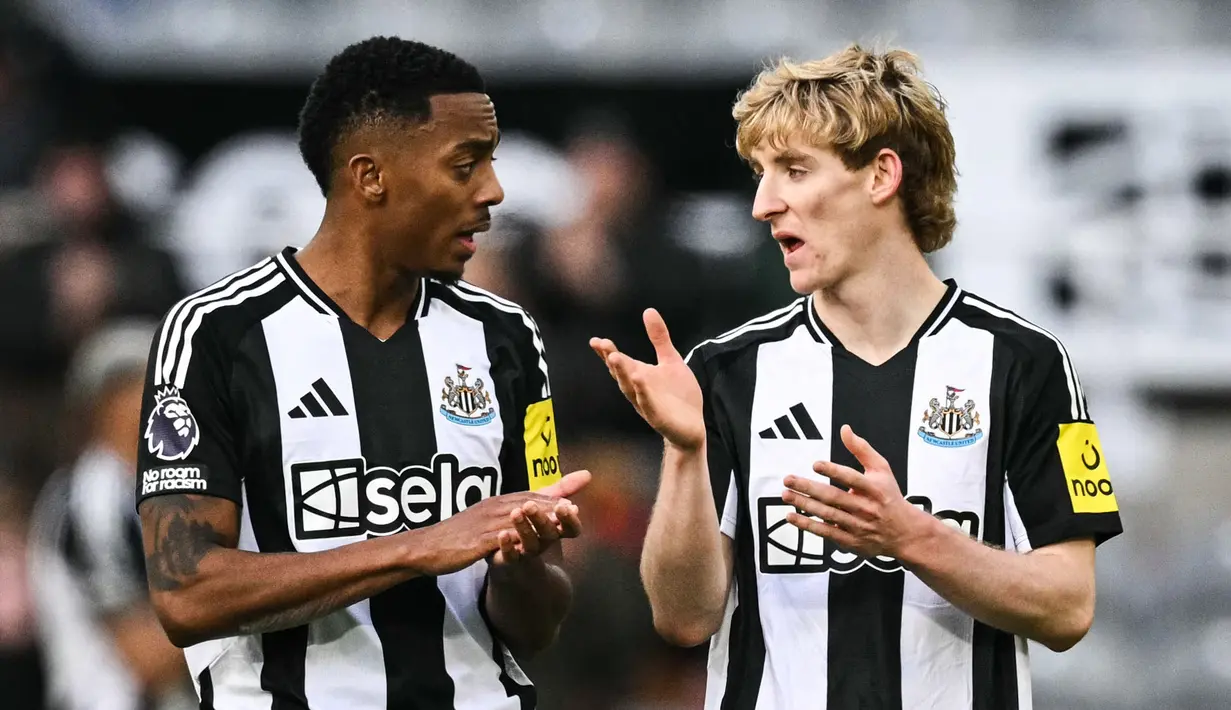 Pemain Newcastle, Anthony Gordon (kanan) berbincang dengan Joe Willock setelah laga leg kedua Carabao Cup 2024/2025 melawan Arsenal di St James Park, Newcastle, Inggris, Kamis (06/02/2025). (AFP/Paul Ellis)