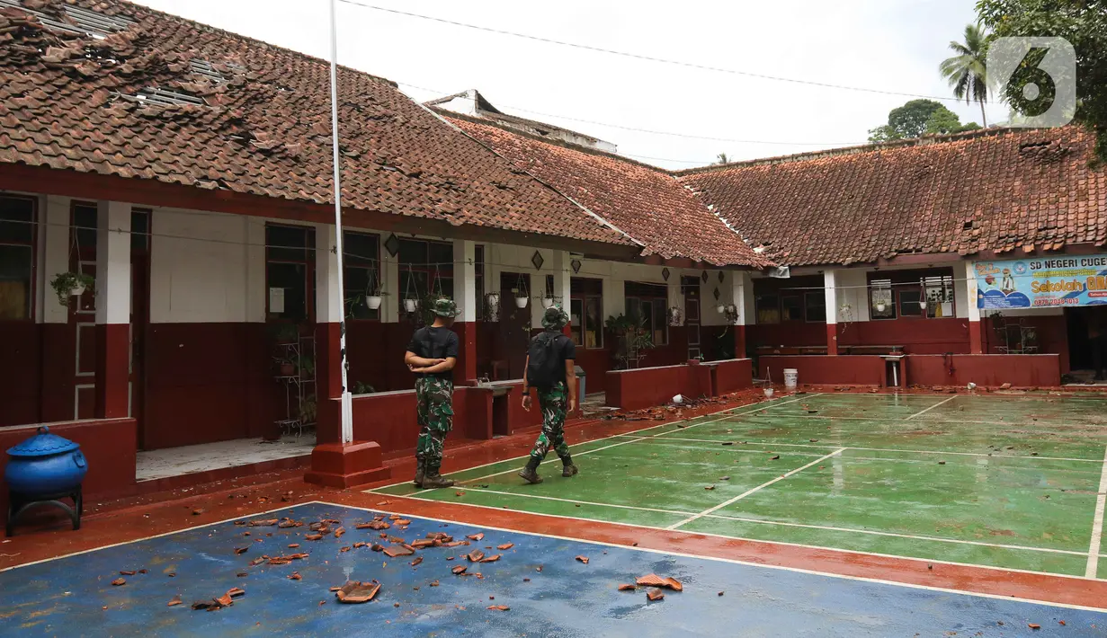 Anggota TNI meninjau bangunan SD Negeri Cugenang yang terdampak gempa bumi di Cianjur, Jawa Barat, Rabu (23/11/2022). Mendikbudristek Nadiem Makarim hari Rabu ini mengunjungi sekolah yang rusak akibat gempa berkekuatan magnitudo 5,6 di wilayah Kabupaten Cianjur pada Senin (21/11/2022) siang. (Liputan6.com/Herman Zakharia)