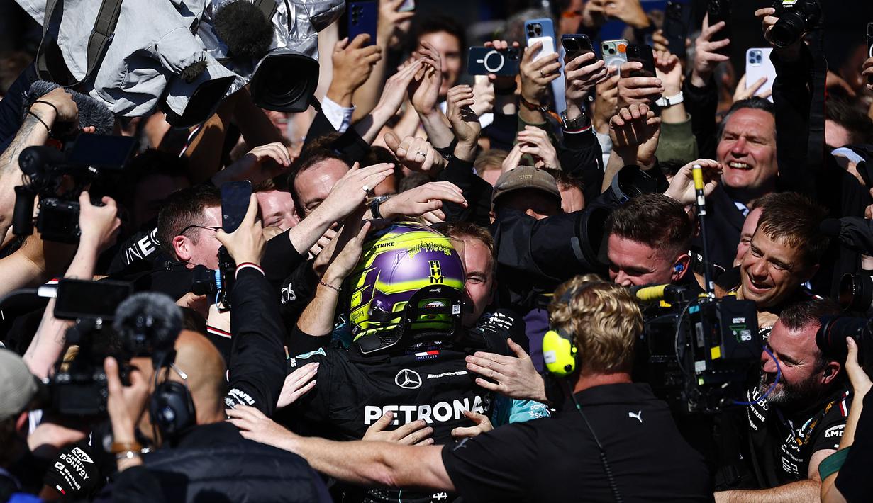Pembalap Mercedes, Lewis Hamilton merayakan kemenangan bersama timnya setelah finis pertama di Formula 1 GP Inggris 2024 yang berlangsung di Sirkuit Silverstone, Inggris, Minggu (08/07/2024). (AFP/Benjamin Cremel)