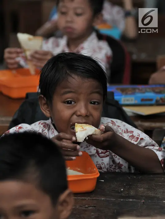 Siswa menyantap makanan tambahan saat program Penyediaan Makanan Tambahan Anak Sekolah (PMTAS) di SD Negeri 01 Tanjung Priok, Jakarta, Kamis (28/3). Pemprov DKI Jakarta menggelontorkan dana Rp 324 miliar untuk memenuhi gizi anak SDN di Jakarta dengan program PMTAS. (merdeka.com/Iqbal S. Nugroho)