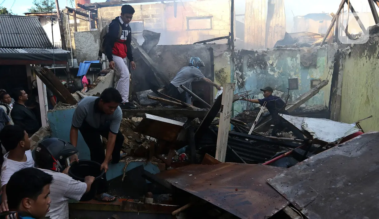 Warga membantu petugas pemadam kebakaran melakukan pendinginan usai kebakaran melanda pemukiman padat penduduk di kawasan Peninggaran Timur, Kebayoran Lama, Jakarta, Senin (27/1/2019). Belum diketahui penyebab terjadinya kebakaran. (Liputan6.com/Johan Tallo)