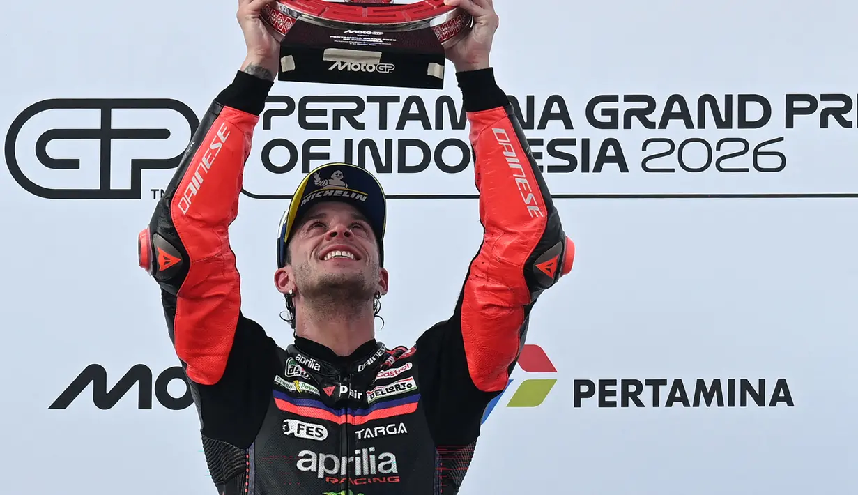 Pembalap Aprilia Racing asal Italia, Marco Bezzecchi, merayakan kemenangan di podium setelah menjuarai balapan MotoGP Indonesia di Sirkuit Internasional Mandalika, Mandalika, Minggu (11/10/2026). (SONNY TUMBELAKA/AFP)