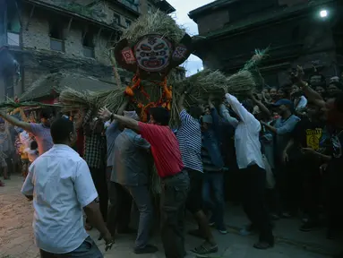 Para lelaki Nepal membawa patung jerami iblis Ghantakarna untuk dibakar dalam festival Ghantakarna di kota kuno Bhaktapur, Nepal (30/7/2019). Festival Hindu ini juga dikenal dengan nama Gathemangal. (AFP Photo/Prakash Mathema)