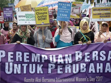 Puluhan massa aksi yang tergabung dalam beberapa aktivis wanita membawa spanduk saat menggelar aksi unjuk rasa dikawasan Patung Kuda, Jakarta, Rabu (8/3). (Liputan6.com/Faizal Fanani)