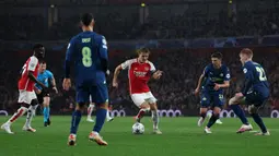 Pemain Arsenal, Martin Odegaard (tengah) berusaha melewati adangan dari sejumlah pemain PSV Eindhoven pada laga Grup B Liga Champions 2023/2024 di Emirates Stadium, London, Kamis (21/09/2023) dini hari WIB. (AFP/Adrian Dennis)