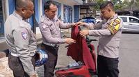 Anggota Satlantas Polres Bangkalan sedang memeriksa isi jok sepeda motor tak bertuan di Terminal Bis Kabupaten Bangkalan.