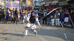 Seorang pria melakukan atraksi bermain senjata saat prosesi keagamaan menjelang ulang tahun kelahiran Guru Gobind Singh di Jammu, India (2/1). Guru Gobind Singh secara resmi menjadi pemimpin orang Sikh pada umur kesembilan. (AP Photo / Channi Anand)