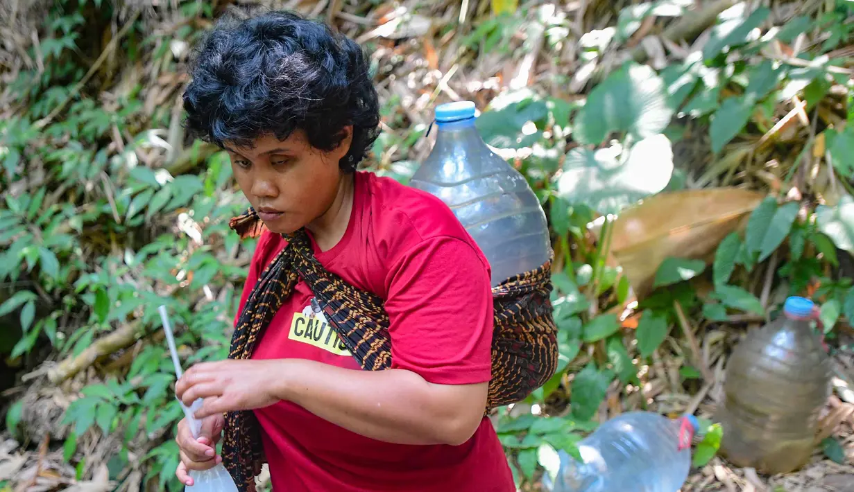 Penyandang tunanetra, Sujanah,berjalan membawa air di kawasan Gunung Batur, Kota Cilegon, Banten, Minggu (19/07/2026). (KLY/Arie Basuki)