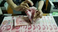 Petugas menghitung uang pecahan 100 Yuan, Jakarta, Kamis (13/8/2015). Biang kerok keterpurukan kurs rupiah dan sejumlah mata uang negara lain adalah kebijakan China yang sengaja melemahkan (devaluasi) mata uang Yuan. (Liputan6.com/Johan Tallo)