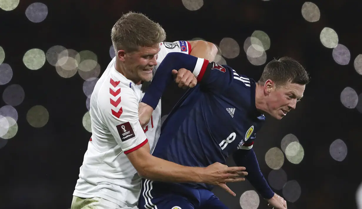 Pemain Skotlandia Callum McGregor (kanan) berebut bola dengan pemain Denmark Andreas Evald Cornelius pada pertandingan sepak bola kualifikasi Grup F Piala Dunia 2022 di Stadion Hampden Park, Glasgow, Skotlandia, 15 November 2021. Skotlandia menaklukkan Denmark 2-0. (AP Photo/Scott Heppell)