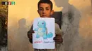 Seorang anak memegang kertas bergambarkan salah satu karakter dalam permainan Pokemon dan tulisan "Aku dari Kafr Naboudah, tolong selamatkan aku", Suriah (22/7). (REUTERS)