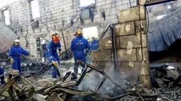 Petugas memeriksa puing-puing sebuah gedung yang hangus terbakar di desa dekat Kiev, Ukraina, Minggu (29/5). Sedikitnya 17 orang tewas orang tewas setelah kebakaran yang menghanguskan sebuah gedung yang digunakan sebagai panti jompo. (REUTERS)