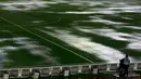 Seorang kamerawan berdiri di pinggir lapangan Stadion Monumental, Buenos Aires, Argentina, yang banjir karena guyuran hujan deras sebelum laga Kualifikasi Piala Dunia 2018 antara Argentina melawan Brasil. Jumat (13/11/2015) WIB. (Reuters/Marcos Brindicci)