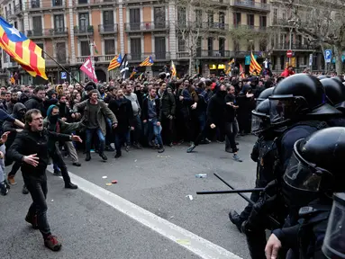 Petugas kepolisian bentrok dengan pendukung pro kemerdekaan Catalonia di Barcelona, Spanyol, Minggu (25/3). Demonstran berusaha mencapai kantor pemerintahan. (Foto AP/Emilio Morenatti)