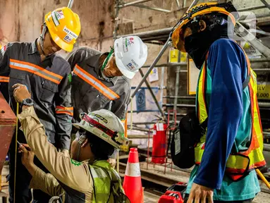 Pekerja mengecek mesin bor terowongan (tunnel boring machine) pembangunan jalur MRT Jakarta fase 2A CP 203 di terowongan bawah tanah Stasiun Kota, Jakarta, Kamis (11/7/2024). (Liputan6.com/Herman Zakharia)