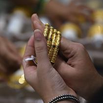 Seorang pelanggan mencoba gelang emas selama festival Hindu 'Akshaya Tritiya', hari keberuntungan dalam kalender Hindu untuk membeli barang-barang berharga, di ruang pamer perhiasan di Chennai, India, Selasa (3/5/2022). Membeli emas adalah kegiatan yang populer di Akshaya Tritiya, karena ini adalah simbol utama kekayaan dan kemakmuran. (Arun SANKAR / AFP)