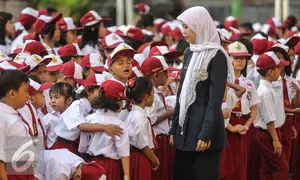 Guru mengatur para murid sebelum upacara di SD Pasar Baru 05, Jakarta, Senin (27/7/2015). Usai libur panjang Idul Fitri para siswa kembali beraktivitas mengikuti pelajaran di sekolah untuk tahun ajaran 2015-2016. (Liputan6.com/Faizal Fanani)