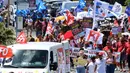 Para pengunjuk rasa mengambil bagian dalam demonstrasi pada hari kelima demonstrasi nasional yang diselenggarakan sejak awal tahun, menentang perombakan pensiun yang sangat tidak populer, di Saint-Denis-de-la-Reunion, di pulau seberang lautan Prancis, La Reunion, Kamis (16/2/2023). (Richard BOUHET/AFP)
