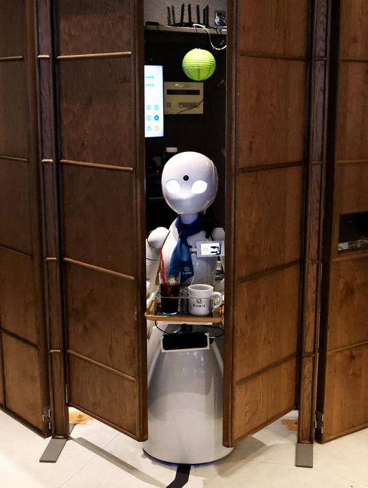 Robot humanoid mengantarkan minuman kepada pelanggan di Dawn Cafe, Tokyo, Jepang, 17 Agustus 2021. Peluncuran kafe ini bersamaan dengan Paralimpiade yang akan dibuka pada 24 Agustus. (Behrouz MEHRI/AFP)