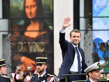 Presiden terpilih Prancis Emmanuel Macron melambaikan tangan saat berparade di jalan Champs Elysees setelah upacara peresmian sebagai Presiden Prancis, Paris, Minggu (14/5). (AFP PHOTO / CHARLY TRIBALLEAU)