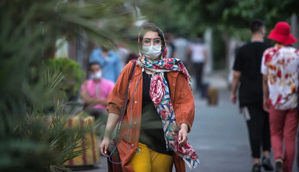 Warga dengan masker melintasi sebuah jalan di pusat Kota Teheran, 28 Juni 2020. Presiden Iran Hassan Rouhani pada Minggu (28/6) mengatakan mengenakan masker di tempat umum akan menjadi wajib mulai pekan depan Di tengah meningkatnya infeksi dan kematian akibat COVID-19. (Xinhua/Ahmad Halabisaz)