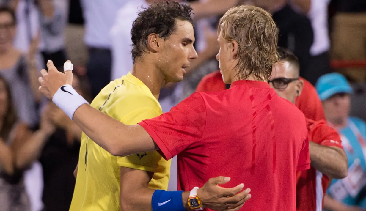 Petenis Spanyol, Rafael Nadal mengucapkan selamat kepada petenis Kanada, Denis Shapovalov seusai turnamen Piala Rogers di Montreal, Kamis (10/8). Nadal disingkirkan petenis 18 tahun itu dengan skor 6-3, 4-6, 6-7. (Paul Chiasson/The Canadian Press via AP)