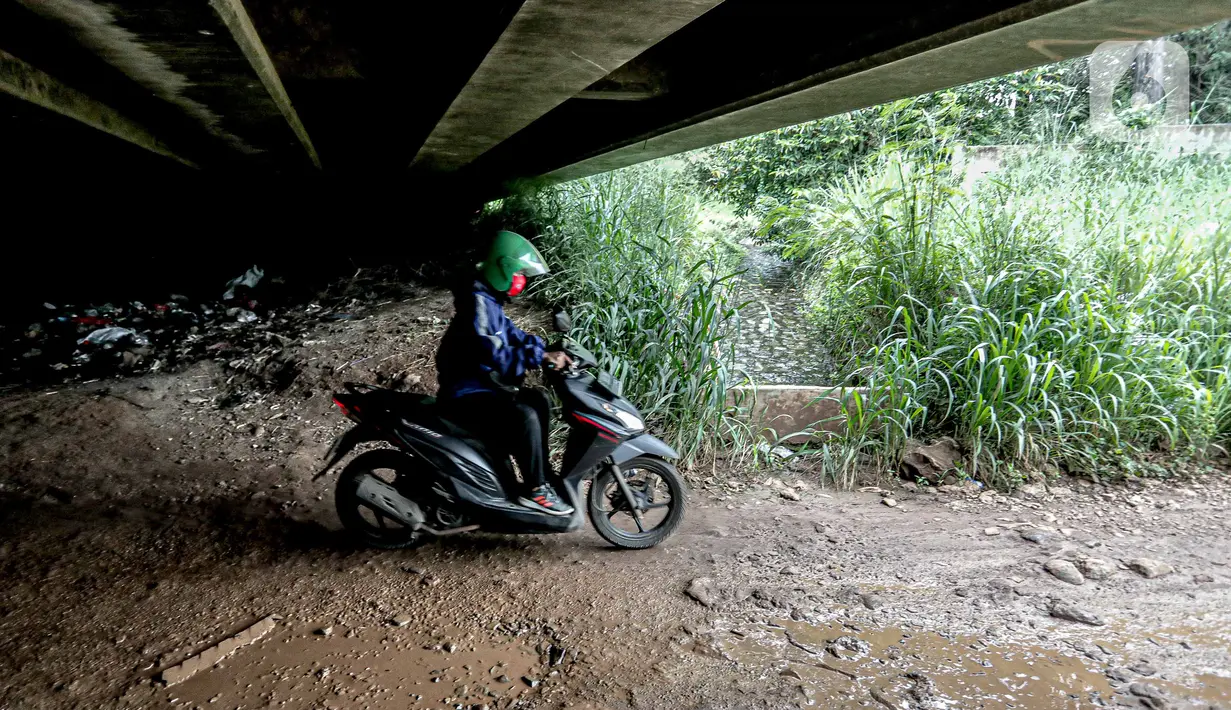Pengendara sepeda motor melintas di kolong Tol Jagorawi, Cimanggis, Depok, Jawa Barat, Minggu (8/11/2020). Buruknya jalan dan minimnya penerangan membuat akses tersebut rawan aksi kejahatan. (Liputan6.com/Faizal Fanani)