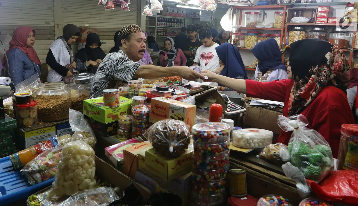 Pedagang melayani pembeli kue kering di Pasar Mayestik, Jakarta Selatan, Senin (11/6). Separuh Ramadan dan jelang lebaran masyarakat mulai berburu kue kering. (Liputan6.com/Johan Tallo)