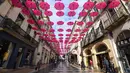 Pejalan kaki melintasi ratusan payung pink yang digantung sebagai tanda dukungan atas kewaspadaan bahaya kanker payudara di Montpellier, Prancis, Selasa (9/10). Bulan Oktober, ditetapkan sebagai bulan kewaspadaan atas kanker payudara. (AFP/PASCAL GUYOT)