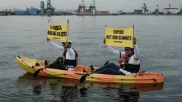 Saat aksi, para aktivis membentangkan spanduk untuk menyoroti inkonsistensi kebijakan energi nasional yang masih mengandalkan bahan bakar fosil, termasuk gas, sebagai solusi transisi energi. Tampak dalam foto, aktivis Greenpeace Indonesia melakukan aksi di kawasan perairan depan Pembangkit Listrik Tenaga Gas Uap (PLTGU) Muara Karang, Jakarta pada Selasa 18 November 2025. (YASUYOSHI CHIBA/AFP)