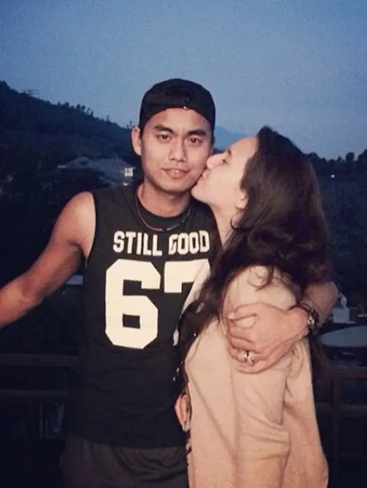 Michelle mendaratkan ciuman mesra di pipi Tontowi yang terlihat macho dengan singlet hitam. (Instagram/ michelle_ahmad)