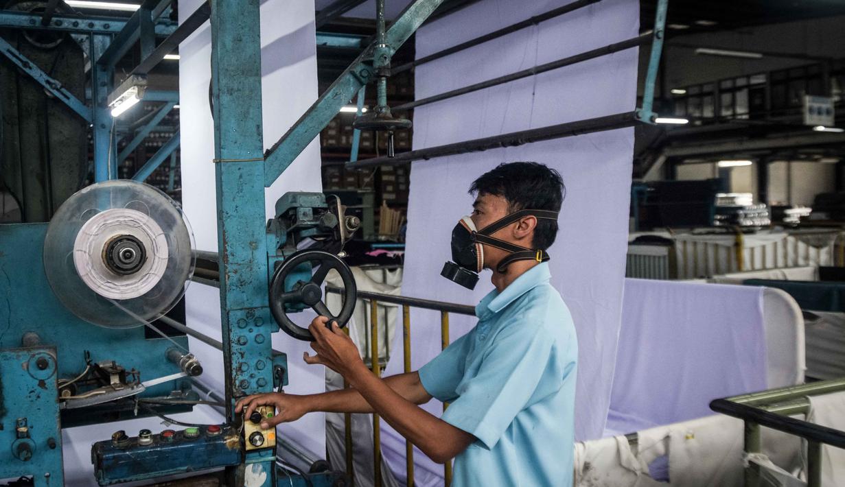 Kenaikan bahan baku ini memicu kekhawatiran akan peningkatan harga jual pakaian di tingkat konsumen, termasuk para pelaku bisnis fashion yang mulai merancang ulang strategi produk dan harga untuk bertahan. Situasi ini juga menuntut adaptasi cepat dari pelaku industri dalam negeri untuk mengelola rantai pasok yang tidak stabil dan biaya produksi yang tinggi. Tampak dalam foto, seorang pekerja mengoperasikan mesin di bagian pewarnaan kain di Trisula Textile Industries, Cimahi, Jawa Barat pada Rabu 22 April 2026, ketika para produsen tekstil menghadapi biaya yang lebih tinggi akibat melonjaknya harga bahan baku petrokimia yang terkait dengan kenaikan harga minyak global. (Timur MATAHARI/AFP)