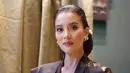 Rambutnya ditata rapi ke belakang dengan gaya klasik modern, dilengkapi dengan hiasan bunga yang mempertegas aura Kartini dalam dirinya.  [@marcella.zalianty].
