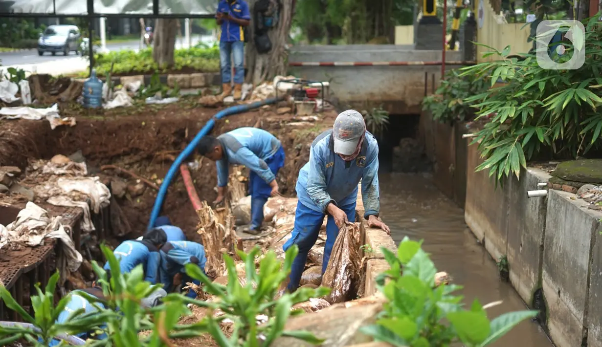 Petugas menyelesaikan pembuatan sumur resapan di kawasan Cempaka Putih, Jakarta, Rabu (25/11/2020). Sebanyak 14 lubang sumur resapan yang dibangun di ruas Jalan Jenderal Ahmad Yani dan Cempaka Putih Barat 21 saat ini terus dikebut pengerjaannya. (Liputan6.com/Immanuel Antonius)